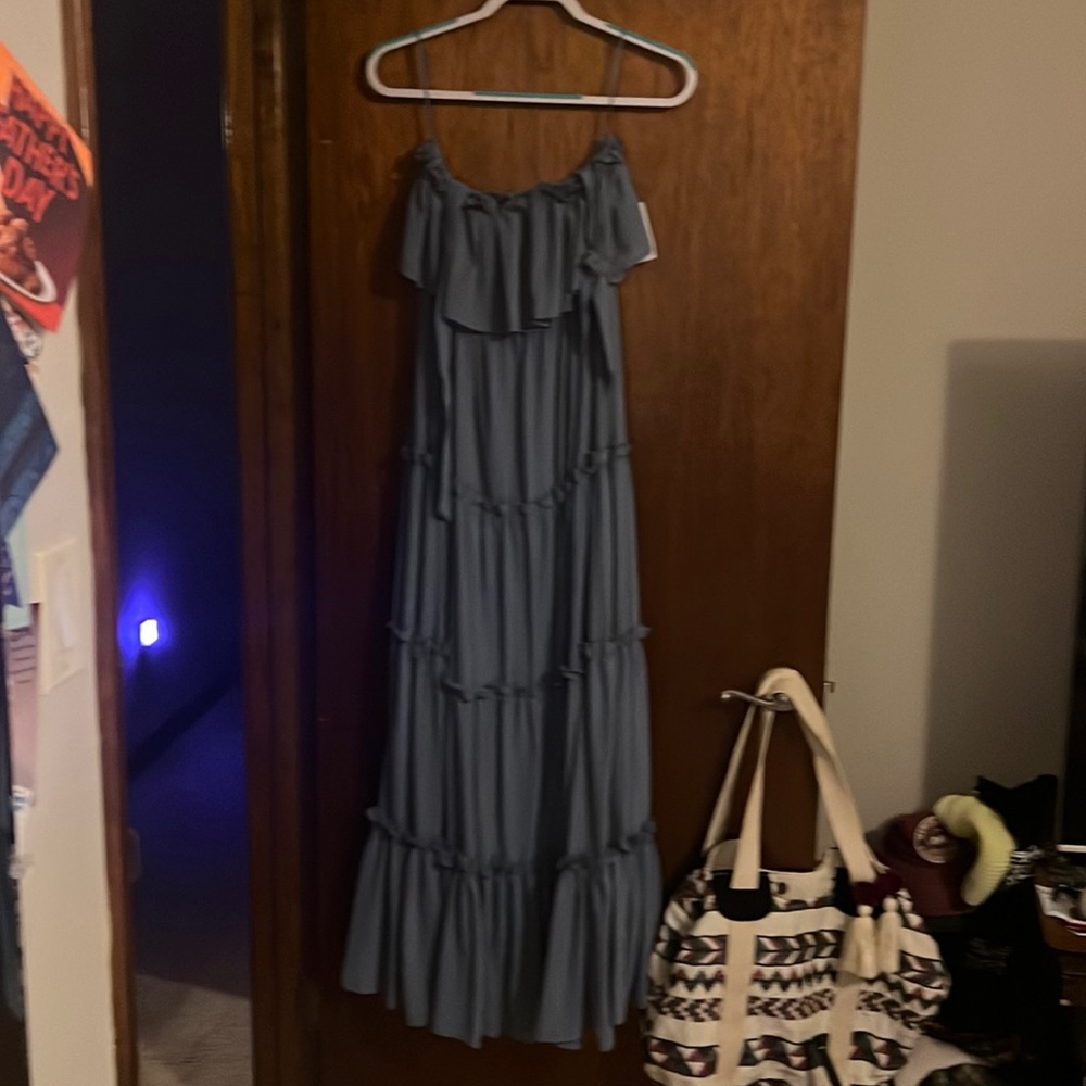 Small tiered maxi dress with tie straps over the shoulders. Light blue color.
